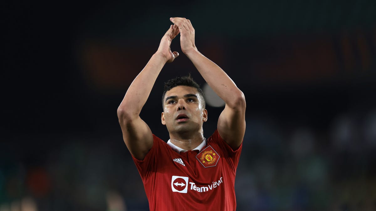 Manchester United midfielder Casemiro clapping hands above his head.