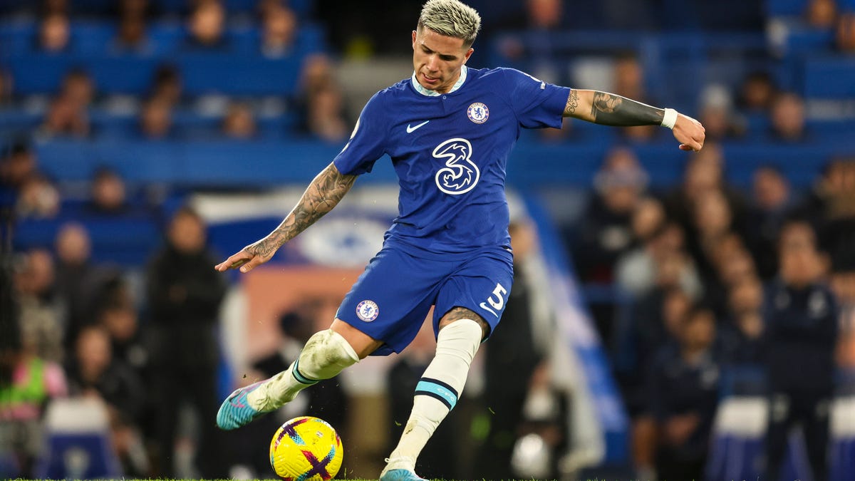 Chelsea midfielder Enzo Fernández kicking a ball with his right foot.